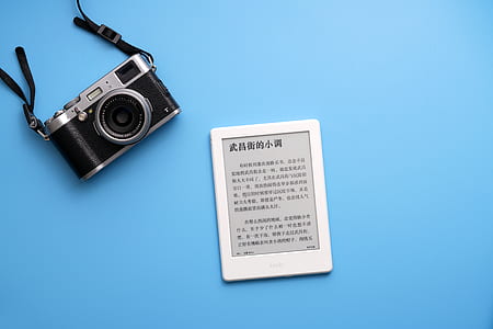black and gray camera beside white E-book reader thumbnail