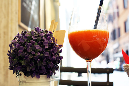 wine glass filled with liquid beside petaled flower arrangement thumbnail