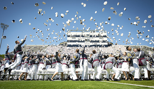 people tossing hats under clear blue sky at daytime thumbnail