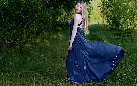 woman in blue gown near tree thumbnail
