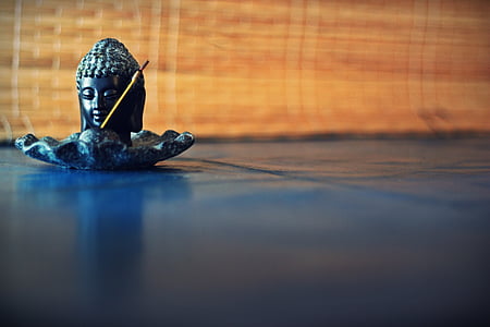 close-up photography of buddha black ceramic figurine on black surface thumbnail