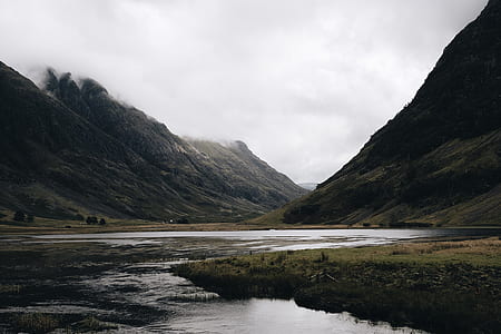 landscape photography of mountain under cloudy sky thumbnail
