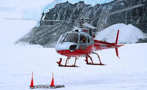 red and white helicopter able to land on snow covered area thumbnail