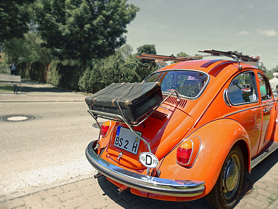 orange Volkswagen Beetle coupe near green leafed trees thumbnail