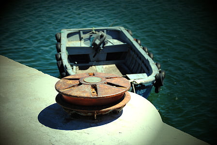 yellow metal pole on dock beside boat on body of water thumbnail