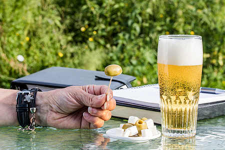 person holding nut beside beer glass thumbnail