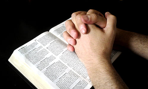 person hand on top of book with black background thumbnail