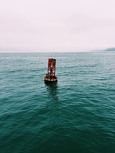 red buoy on bodies of water thumbnail