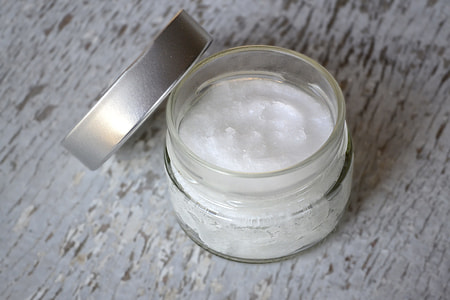 white cream in clear glass case on top of gray wooden surface thumbnail