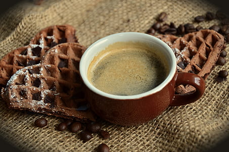 coffee filled brown cup beside coffee beans and heart chocolate chips thumbnail