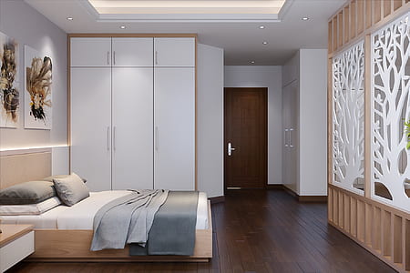 two gray and black bedspreads on bed near white wooden cabinet thumbnail