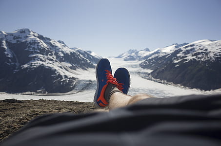 person wearing blue-and-red shoes lying on dirt during daytime thumbnail