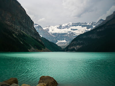 body of water beside mountain thumbnail