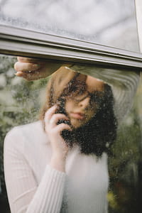 woman leaning on mirror while holding smartphone thumbnail