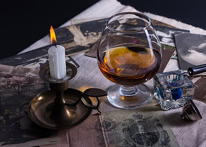 short-stem wine glass placed beside dome candlestick on table thumbnail