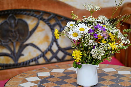 assorted-color flowers in white vase on table thumbnail