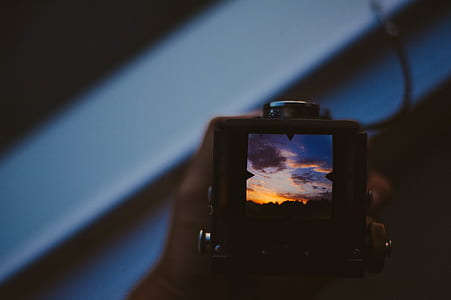 person holding black camera thumbnail