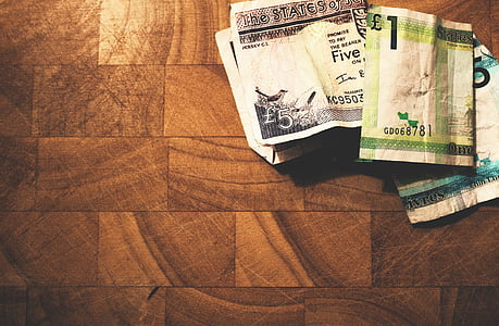 three assorted-denomination banknotes on brown surface thumbnail