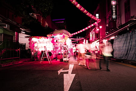 time lapse photo of people walking on road at night tim thumbnail
