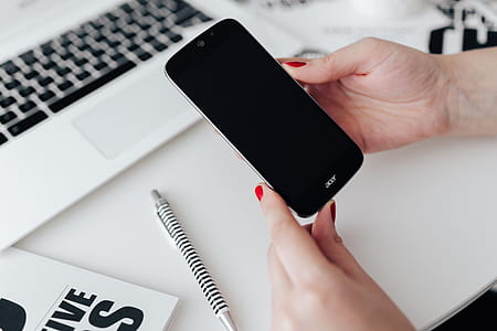 Businesswoman uses her mobile phone at her desk thumbnail