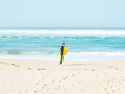 man carrying bodyboard on shoreline thumbnail