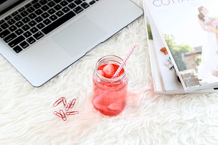 flat-lay photography of pink liquid drink near silver MacBook thumbnail