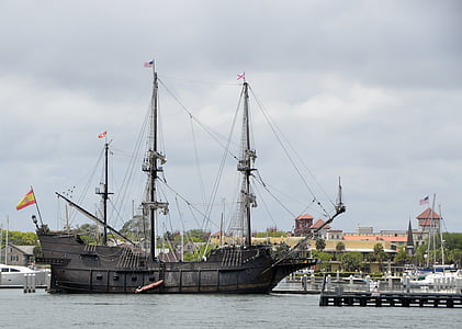 black sailing ship near concrete structures thumbnail