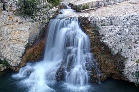 timelapse photography of waterfalls between gray rocks thumbnail