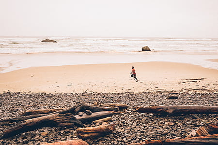 person running beside seashore thumbnail