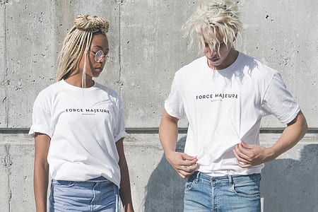 man and woman standing side-by-side near gray concrete wall outdoor during day thumbnail