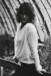 grayscale photo of woman with long-sleeved top and black bottoms thumbnail