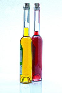 two green labeled glass bottles filled with yellow and red liquids thumbnail
