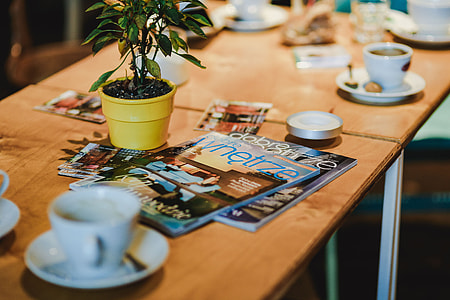 Laptop, a smartphone, magazines and cups of coffee on a table thumbnail