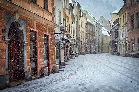 pathway covered with snow between buildings thumbnail
