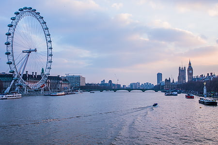 Ferris Wheel near buildings viewing calm sea under blue skies thumbnail