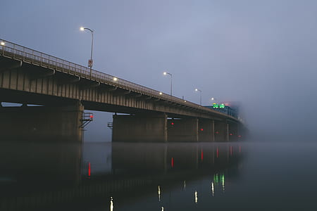 low angle view of concrete bridge over body of water with fogs thumbnail