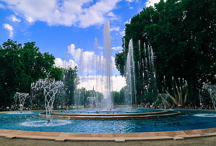 concrete fountain near trees at daytime thumbnail