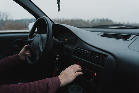 person wearing maroon long-sleeved shirt sitting inside vehicle interior thumbnail