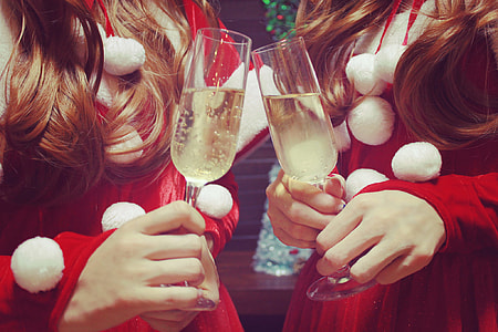two women in red dresses holding wine glasses thumbnail