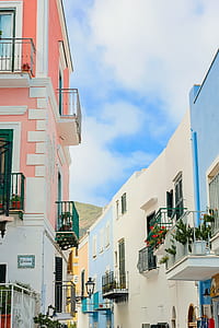 pink, blue, and white balcony with flowers under blue cloudy skies thumbnail
