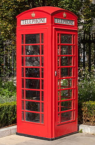 red telephone booth near green trees during daytime thumbnail