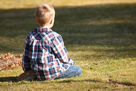 boy sitting on green grass thumbnail