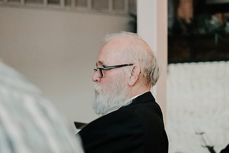 man wearing black blazer near white wall thumbnail