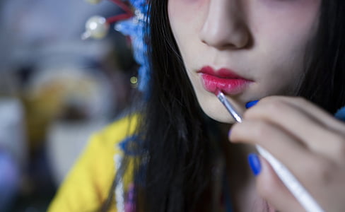 person putting lipstick on woman's lips thumbnail