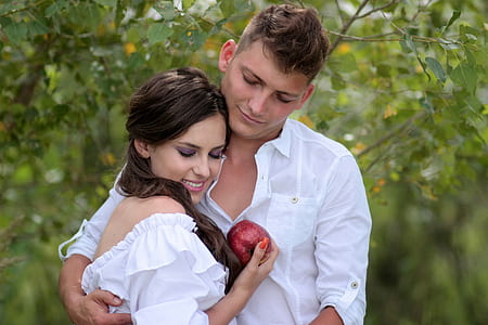 woman in white off-shoulder holding red apple man holding woman thumbnail