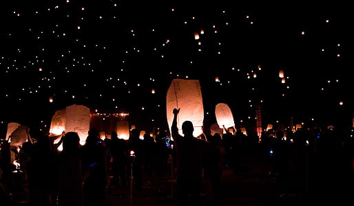 silhouette of people under floating lanterns thumbnail