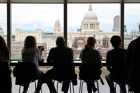 silhouette of four people sitting on chair in front of white dome building thumbnail