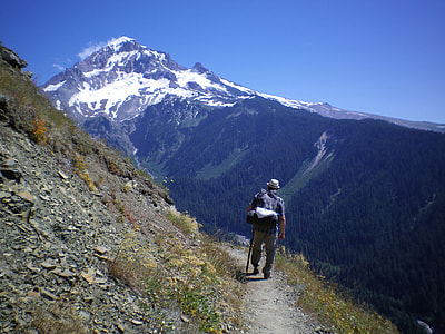 man standing on a mountain under blue skies during daytime thumbnail
