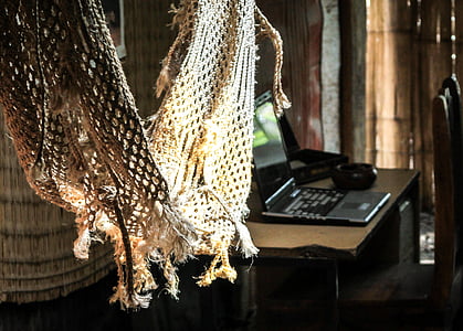 brown broken hammock near black laptop computer on brown wooden table thumbnail