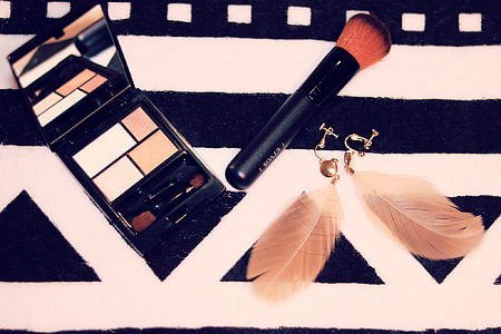 black makeup palette and brush on top of textile thumbnail